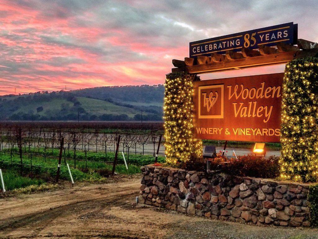 Wooden Valley Winery sign with vineyards behind and sunset sky in Suisun Valley, Fairfield, CA