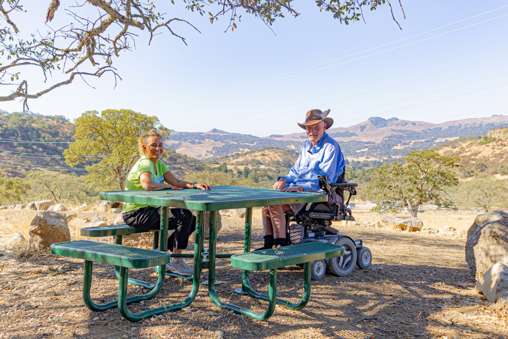 a man and woman sitting at a picnic table