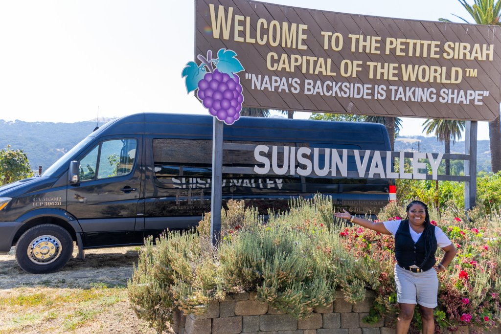 Tam's with Petite Sirah Capital of the World sign and black shuttle in the background